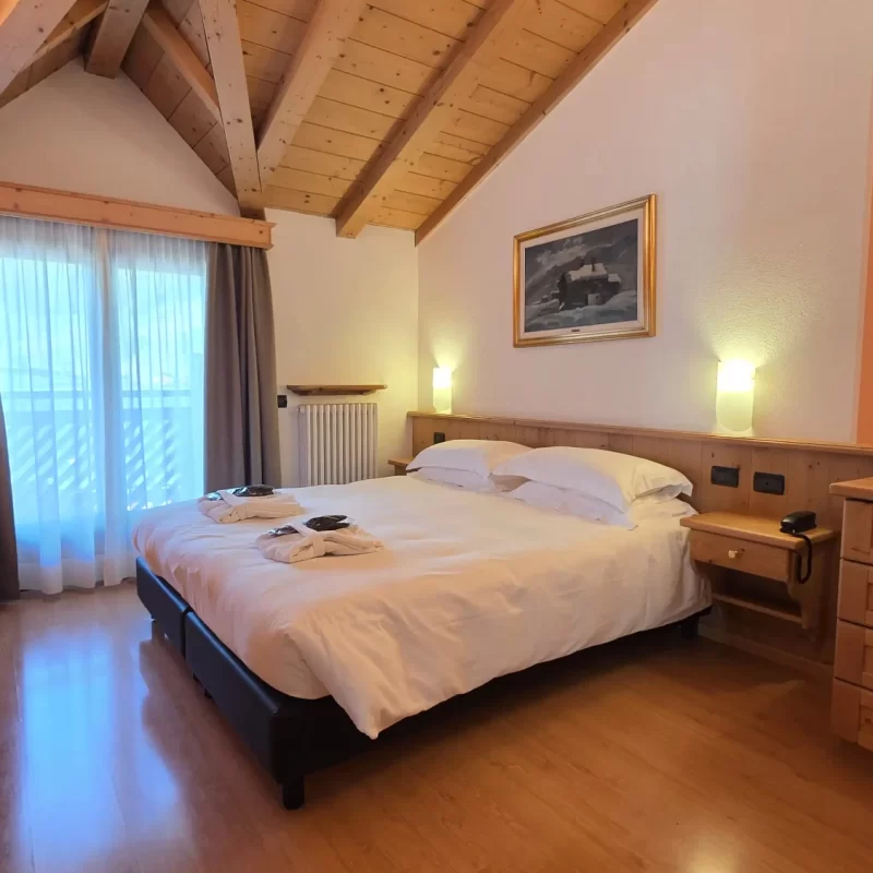 Gemütliches Schlafzimmer mit Holzdach und Einrichtung im rustikalen Stil.