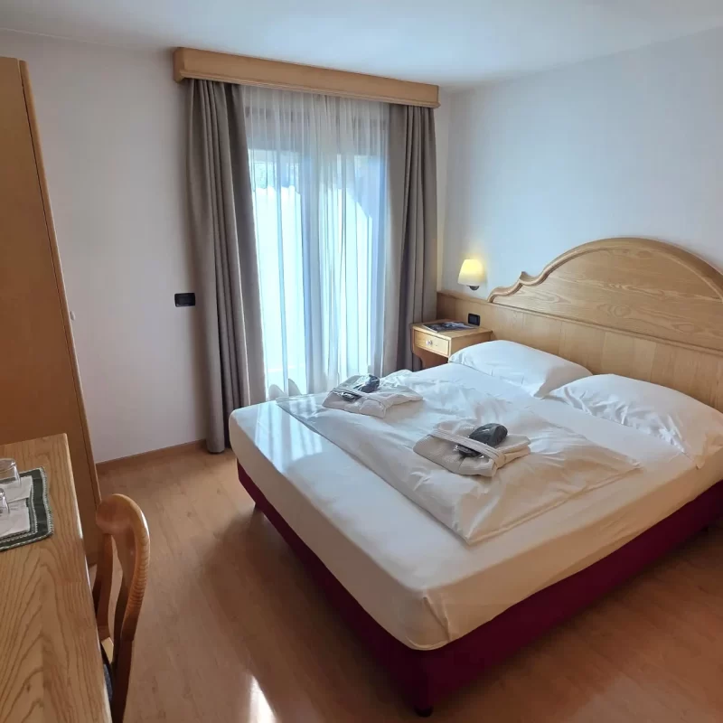 Gemütliches Hotelzimmer mit Doppelbett, Tisch und Fernseher.