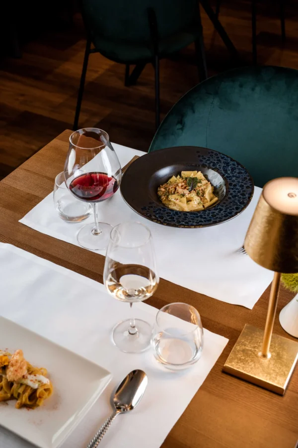 Un elegante tavolo da ristorante apparecchiato con piatti gourmet e calici di vino.