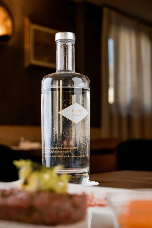 Bottiglia di acqua frizzante su un tavolo in un ambiente elegante.