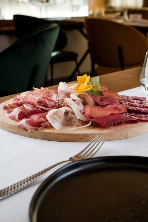 Tagliere di salumi assortiti su un tavolo apparecchiato.