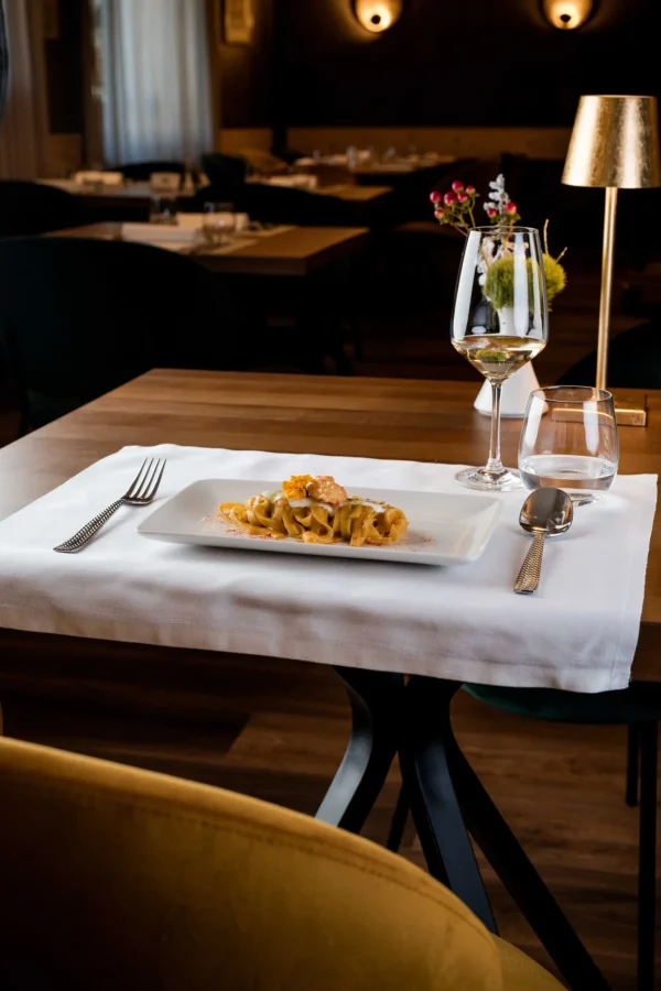 Piatti di pasta gourmet su un tavolo elegante in un ristorante raffinato.