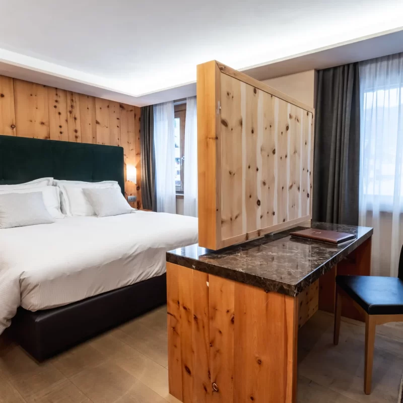 Modernes Schlafzimmer mit Doppelbett, Holzwänden und Schreibtisch mit Stuhl.