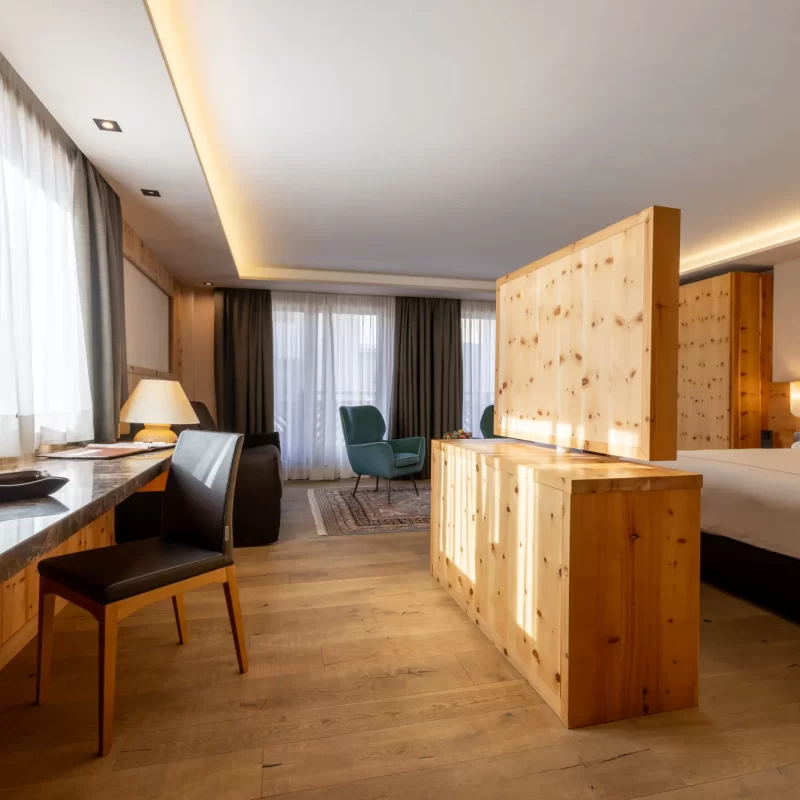 Modernes Hotelzimmer mit Holzmöbeln und Tageslicht.